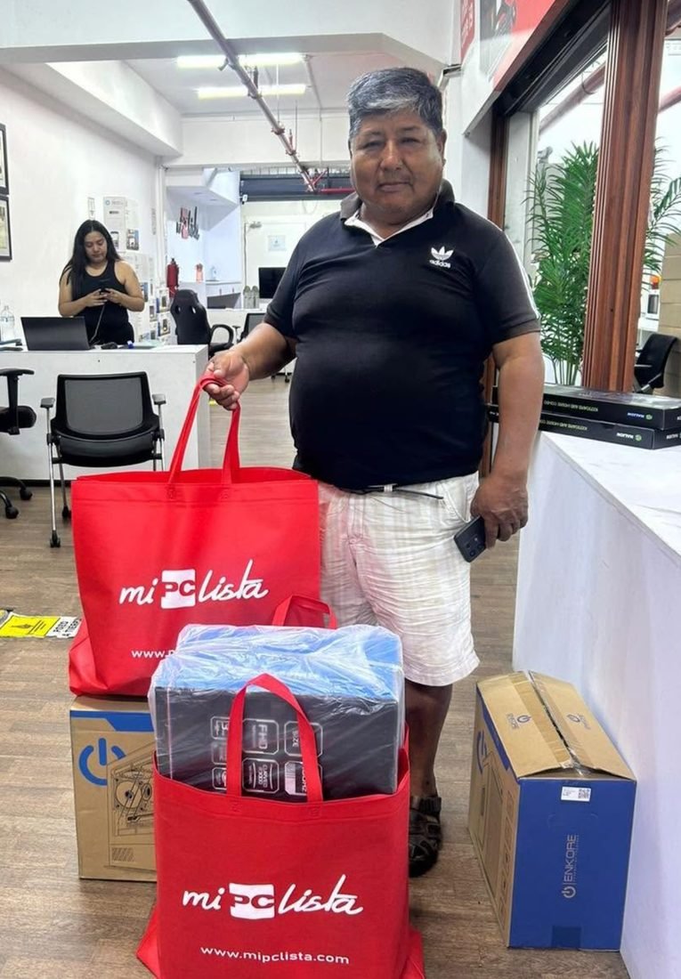 Cliente con su PC gamer y las bolsas de su compra en la tienda